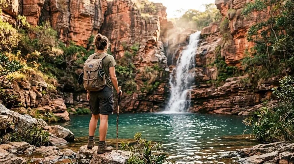 Pessoa observando cachoeira cristalina cercada por formações rochosas do cerrado maranhense